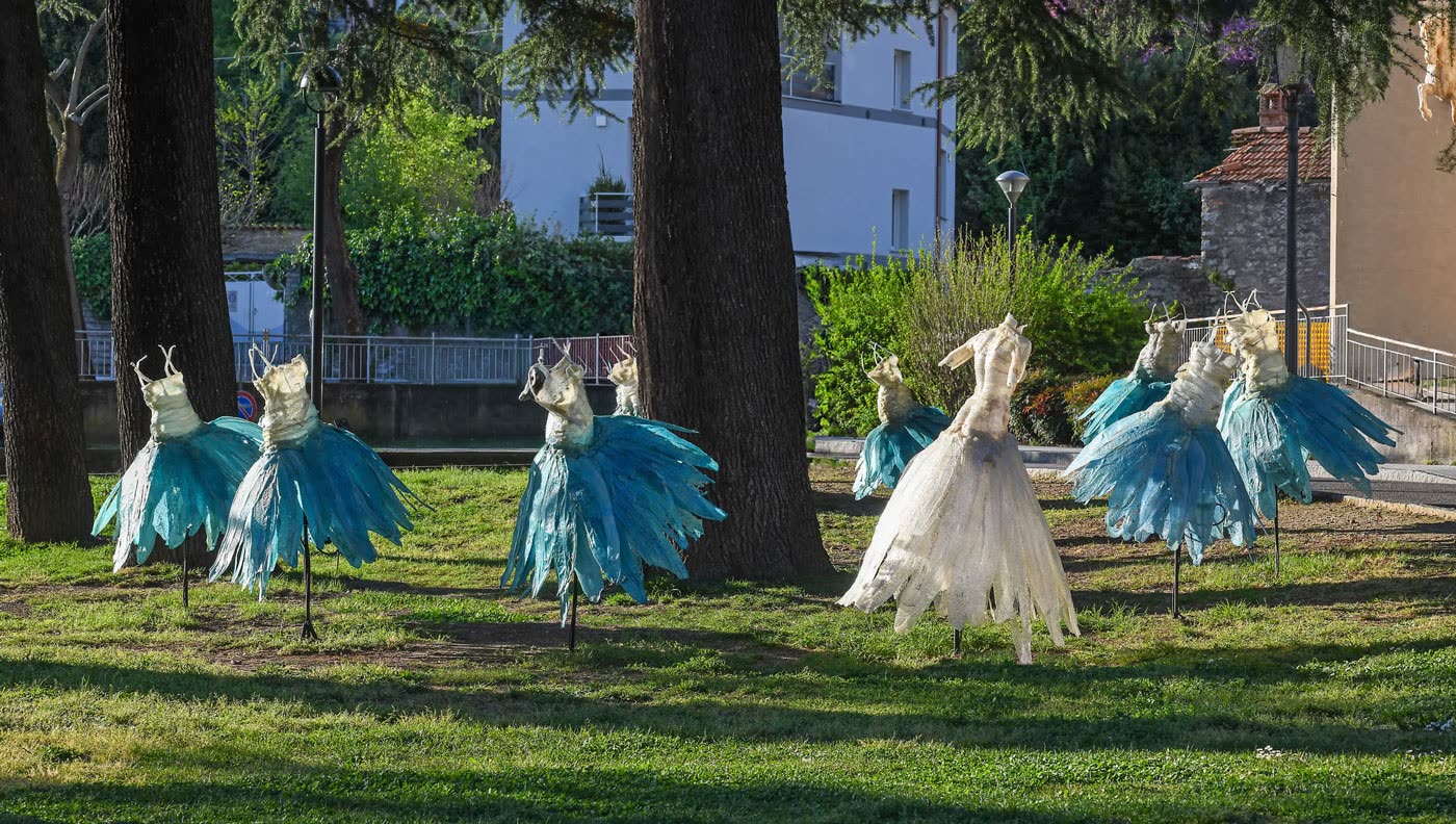 Gruppo di figure con gonne turchesi su un prato