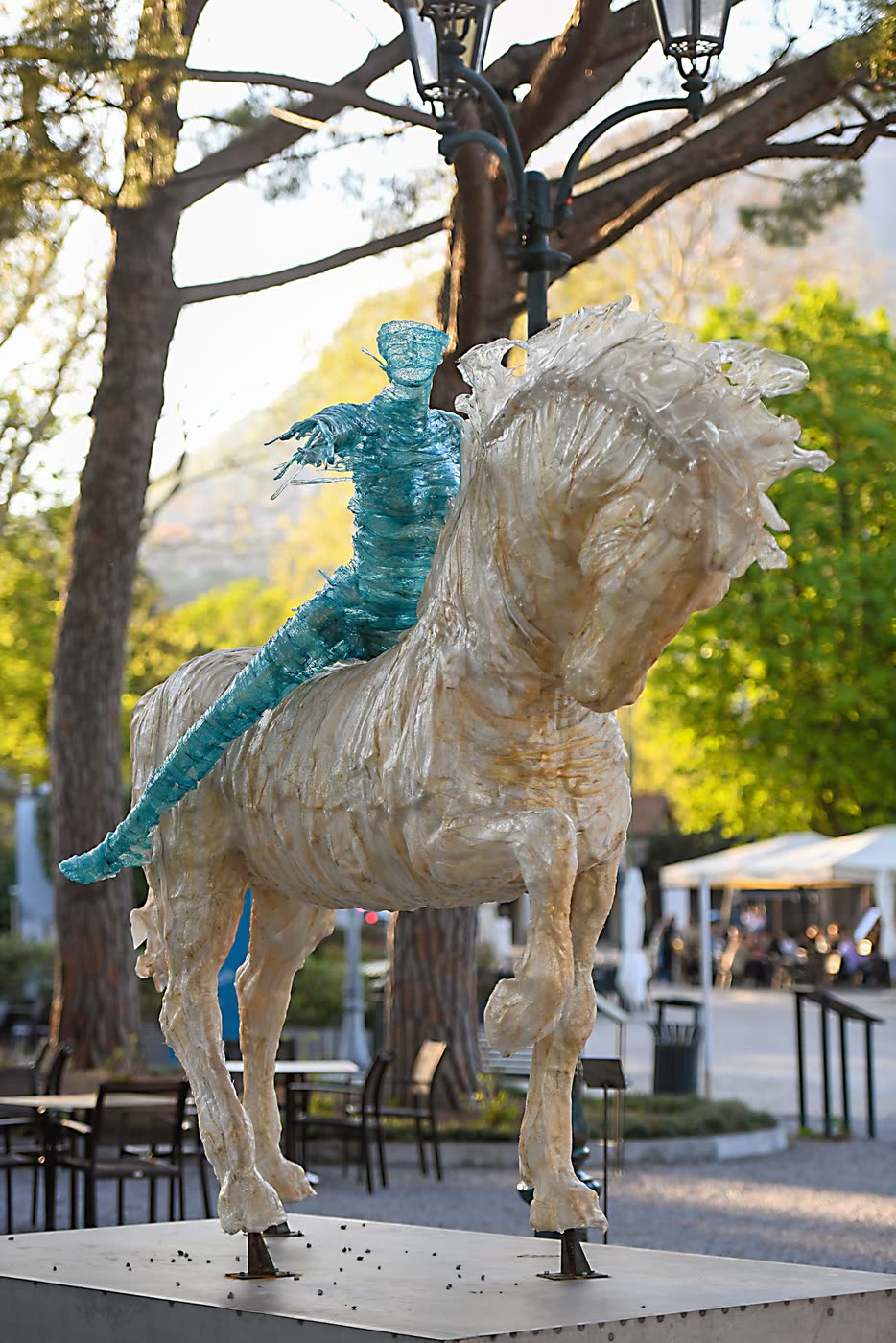 Cavallo con figura turchese in una piazza alberata