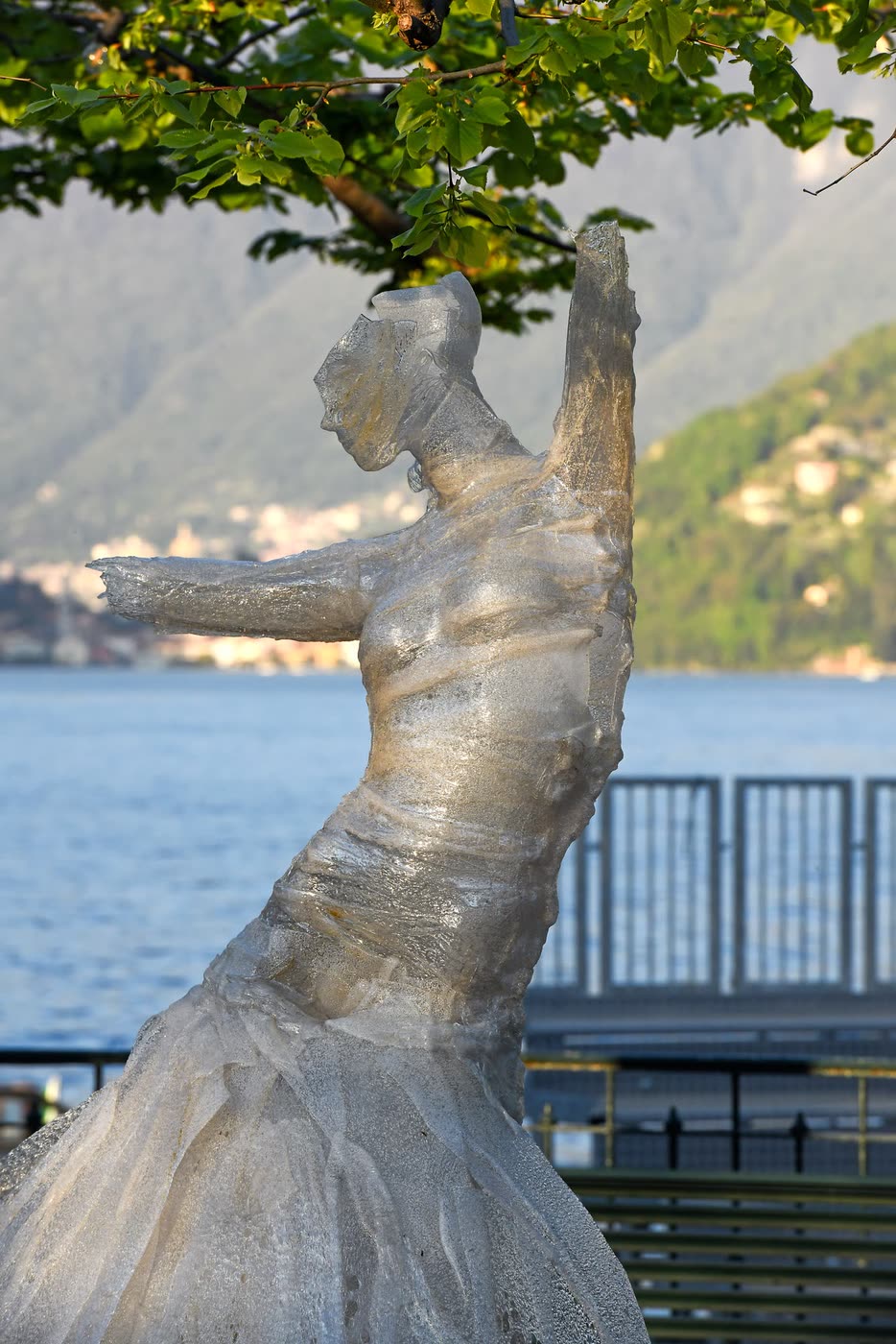 Figura femminile con le braccia alzate sul lungolago